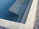 Ambiance margelle de piscine en pierre reconstituée Domus pierre-reconstituee-margelle-piscine-aspect-pierre-angle-sortant-blanc-ivoire